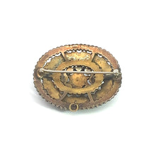 Load image into Gallery viewer, The Victorian Vermeil Oval Garnet Brooch is an intricately designed piece from the Victorian era, boasting a metallic gold finish. The back side showcases a pin mechanism for fastening. This vintage charm presents a textured, scalloped edge and a central circular pattern, radiating timeless elegance.