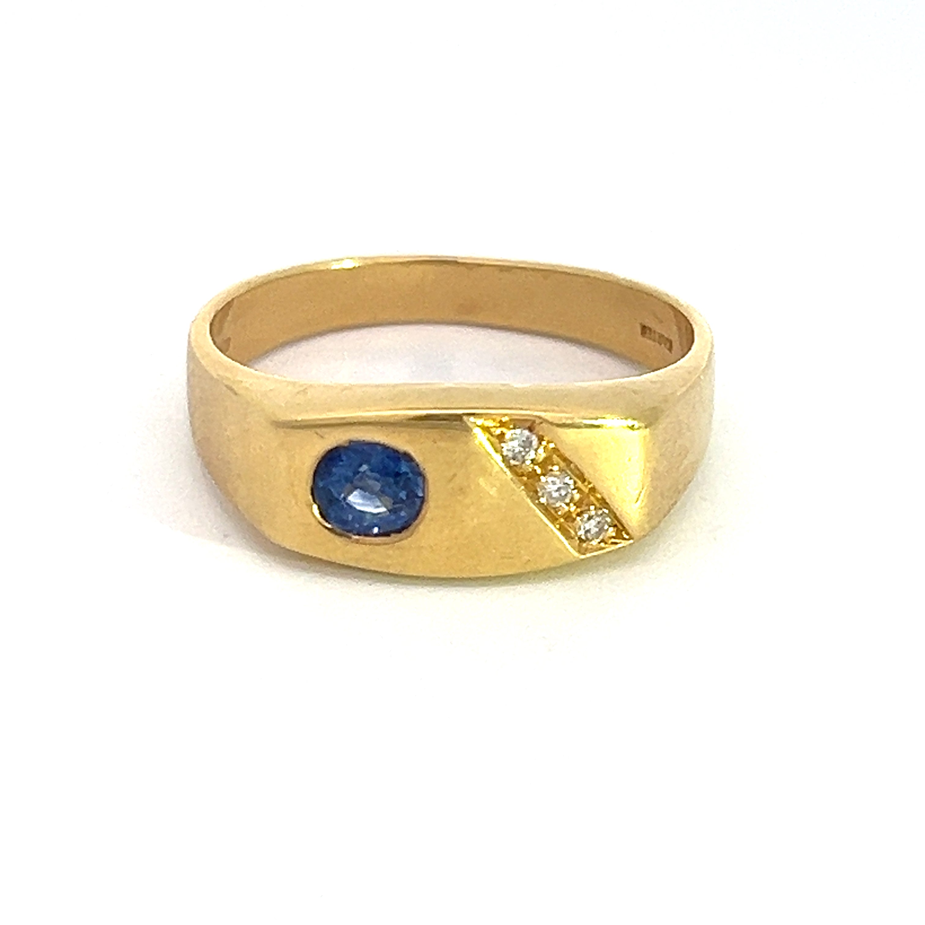 The Mid Century 18k yellow gold ring features a .50ct sapphire gemstone positioned on the left side, complemented by three .15cttw diamonds diagonally aligned on the right side of the band, all set against a plain white background.