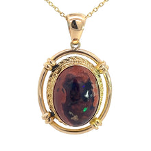 Load image into Gallery viewer, The Late Century 14kt Yellow Gold 5ct Boulder Opal Fancy Frame Pendant boasts a gold setting with an intricately designed frame, cradling a polished, oval-shaped boulder opal that showcases a unique pattern of shimmering iridescent flecks and vintage charm. This elegant pendant hangs gracefully from a delicate gold chain.