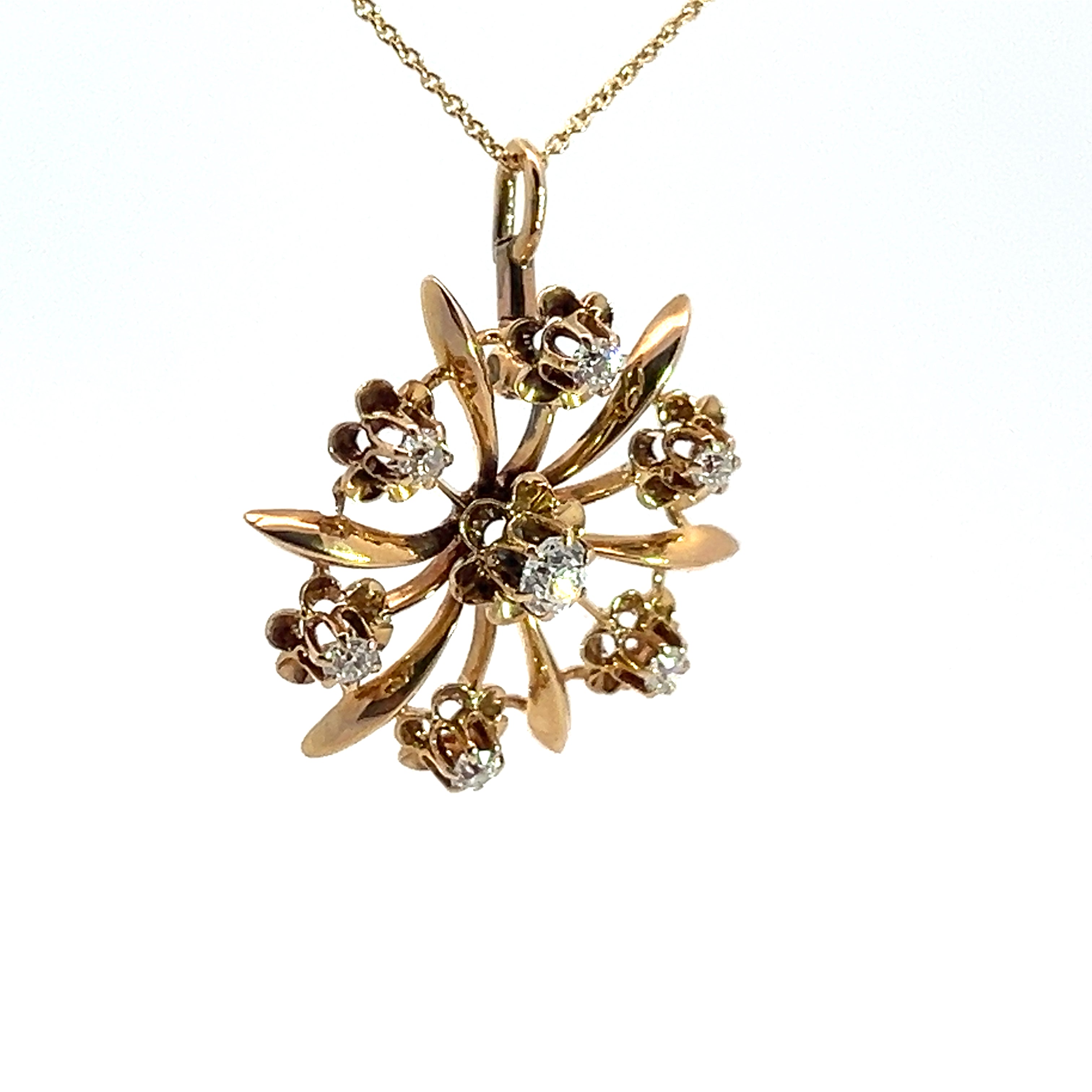 The Victorian 14ktyg .80cttw old mine cut diamond pendant is a stunning necklace crafted from 14kt yellow gold, featuring a floral design with seven old mine cut diamonds arranged in a circular pattern. The central stone is larger and surrounded by six smaller stones, each set within a delicate gold flower. Reflecting the elegance of the Victorian era, the chain is composed of thin, delicate gold links.