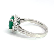 Load image into Gallery viewer, A Modern 18kt White Gold 1.80ct Emerald + .50cttw Diamond Ring showcasing a large emerald gemstone in a raised prong setting. The band is embellished with small, round white diamonds totaling .50cttw along the sides, enhancing its elegance. Positioned on a white background, it emphasizes the intricate details of this exquisite piece.