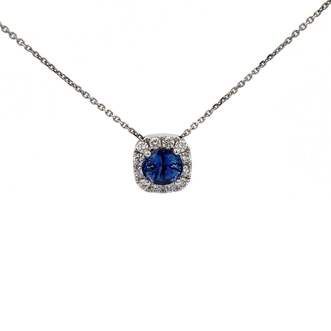 A delicate Modern 14kt White Gold necklace featuring a stunning 1.03ct blue sapphire pendant surrounded by shimmering .36cttw diamonds. The pendant elegantly hangs from a thin, white gold chain against a plain, white background.