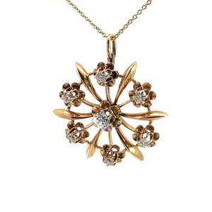 The Victorian 14ktyg .80cttw old mine cut diamond pendant features a golden flower with six petals and six smaller flowers encircling a central Old Mine Cut Diamond, all encrusted with sparkling diamonds. Crafted from luxurious 14kt Yellow Gold, the pendant hangs gracefully from a fine gold chain, epitomizing the elegance of the Victorian era.