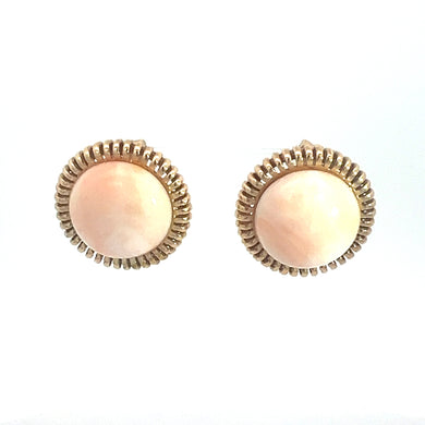 Product Description: The Mid Century 14ktyg Angel Skin Coral Clip on Earrings feature round Angel Skin Coral stones set in 14kt yellow gold frames with intricate, textured borders. The soft hue of the coral contrasts beautifully with the shiny gold, creating an elegant and classic design. These exquisite mid-century earrings are showcased against a plain white background.