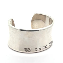 Load image into Gallery viewer, The Modern Tiffany Sterling Silver Cuff Bracelet c.2001 by Tiffany &amp; Co. is a wide, polished silver cuff featuring an engraved &quot;T &amp; CO&quot;, a &quot;925&quot; stamp signifying its sterling silver composition, and the 1837 hallmark near the edge. Designed with an open back for easy wearing, this bracelet effortlessly combines elegance with contemporary style.