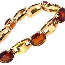 Load image into Gallery viewer, A close-up view of the Retro 14kt Yellow Gold 30cttw Madeira Citrine 7in Bracelet adorned with alternating dark amber gemstones and unique geometric gold links. The oval-shaped gemstones are set in prong settings, providing a striking contrast to the polished 14kt yellow gold. This bracelet exudes retro charm, making it both elegant and luxurious.
