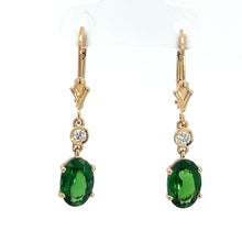 Load image into Gallery viewer, Introducing the Modern 14kt Yellow Gold 2.25ct Tsavorite Garnets + .10cttw Diamond Earrings: A sophisticated pair of drop earrings adorned with oval-shaped Tsavorite Garnet gemstones set in luxurious 14kt yellow gold. Each earring features a small, round diamond above the vibrant green gem, connected to elegant gold hooks by a delicate link. These exquisite earrings are showcased against a pristine white background.